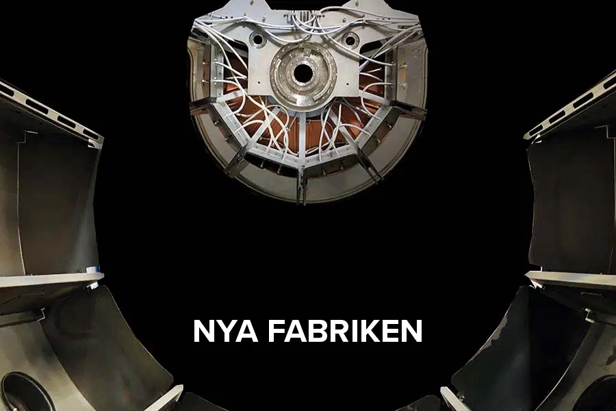 Close-up of a sputter machine. White text with "Nya fabriken"".