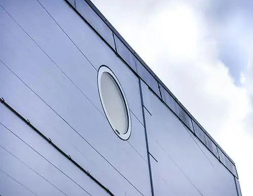 Outside view of a grey facade with a round solar powered smart glass.